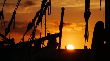 Parlak yuvarlak güneş okyanusa battı. Bir balıkçı teknesinden görüldü.