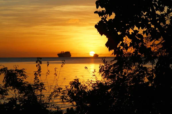 Silhuetas Árvores Navio Distância Com Sol Redondo Completo Começando Pôr — Fotografia de Stock