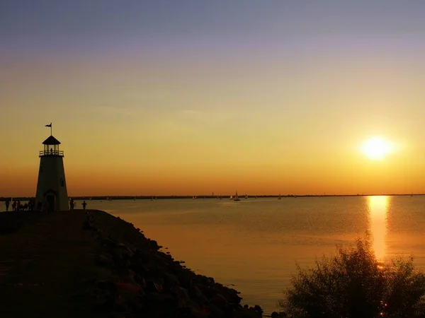 灯塔的轮廓 湖面上的夕阳西下 映照在水面上 — 图库照片