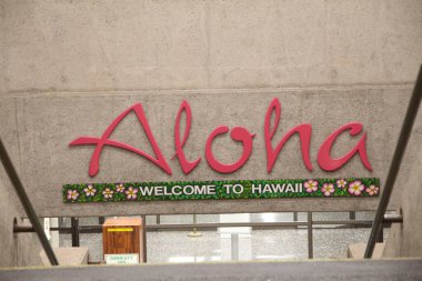 Honolulu, Hawaii-Eylül 2015: Ddaniel K. Inouye Uluslararası Havaalanı 'nın varış alanının merdivenlerinde Aloha işareti.