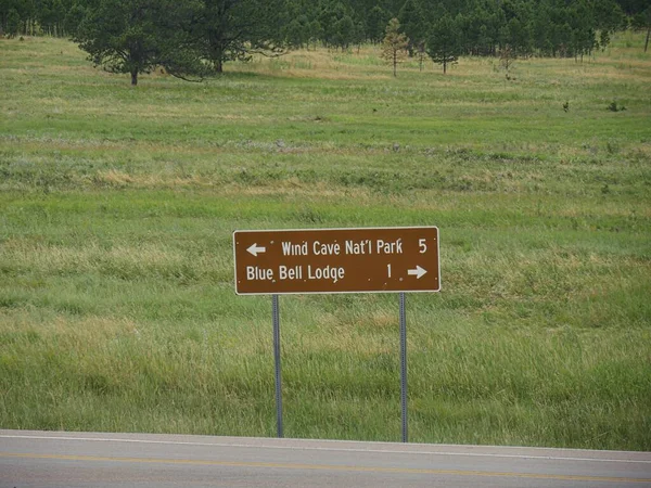 位于南达科他州卡斯特州立公园的风洞国家公园和蓝色钟楼的路标 — 图库照片