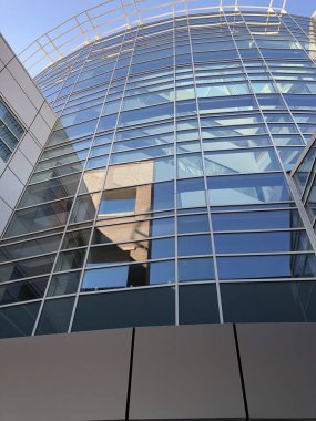 Çok katlı bir binanın cam pencerelerinin yukarı doğru görüntüsü.