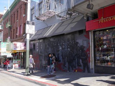San Francisco, Kaliforniya-Temmuz 2018: Sokaklarda dikilen insanlar Çin Mahallesi, San Francisco 'daki bir binanın duvarlarında devasa duvar resimleri ile.