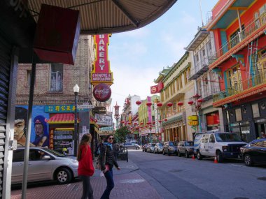 San Francisco, Kaliforniya-Temmuz 2018: Çin Mahallesi, San Francisco 'da karşıdan karşıya geçmek için bekleyen iki kadının bulunduğu renkli binalar..