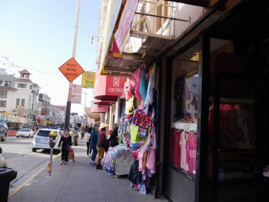 San Francisco, Kaliforniya-Temmuz 2018: Renkli giysiler ve tekstil bir mağazanın önünde sergileniyor ve müşteriler bunları Çin Mahallesi, San Francisco 'da kontrol ediyor..