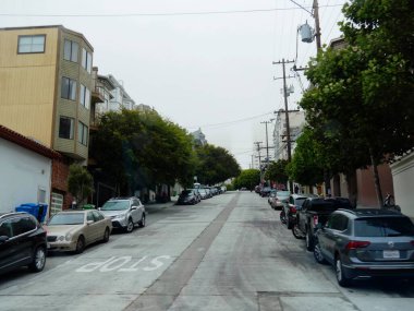 San Francisco, California-Temmuz 2018: Yamuk sokağın her iki tarafında da konut binalarının önüne park edilmiş arabalar.