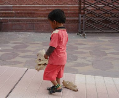 Agra, Uttar Pradesh, Hindistan - Mart 2018: Hindistan 'da popüler bir yer olan Tac Mahal' in içinde bir çocuk yürüyüş yolunda yürüyor. 
