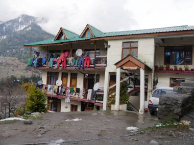Manali, Himachal Pradesh, Hindistan - Mart 2018: Balkonlarda giysileri asılmış bir ev binası.