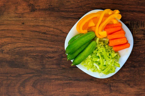 Смачна морква, огірки, капуста і перець на білій тарілці — стокове фото