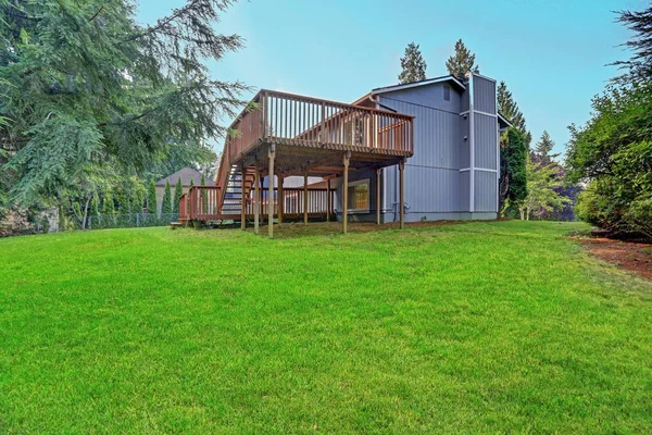 Backyard view of grey rambler house with upper and lower decks — Stock Photo, Image