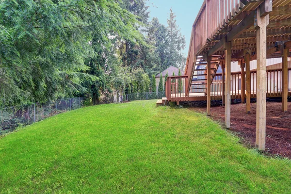 Вид на задний двор серого дома с верхней и нижней палубами — стоковое фото