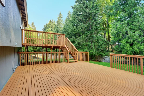 Backyard view of grey rambler house with upper and lower decks — Stock Photo, Image