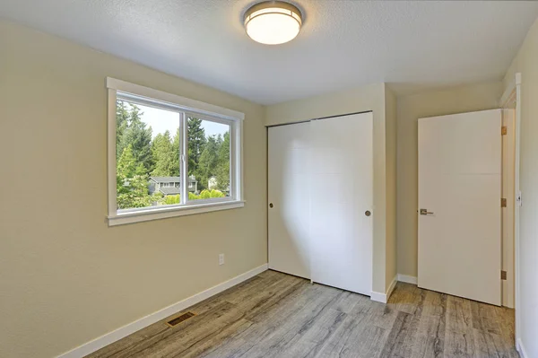 Luminosa camera vuota beige con pavimento in legno grigio — Foto Stock