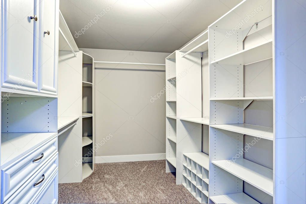 Narrow walk-in closet lined with built-in drawers