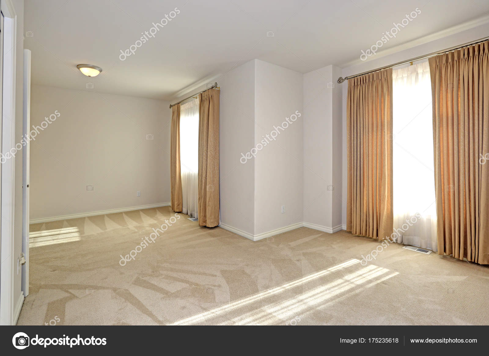 Empty Sun Filled Room With Carpet Floor And Cream Walls