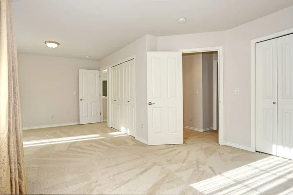Habitación vacía llena de sol con suelo de alfombra y paredes de crema — Foto de Stock