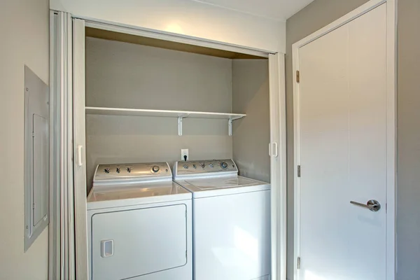Lavandería escondida detrás de puertas plegables blancas — Foto de Stock