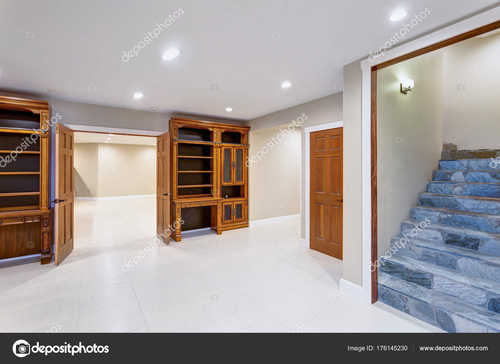 Spacious Empty Basement Area With Custom Built Bookcases Stock
