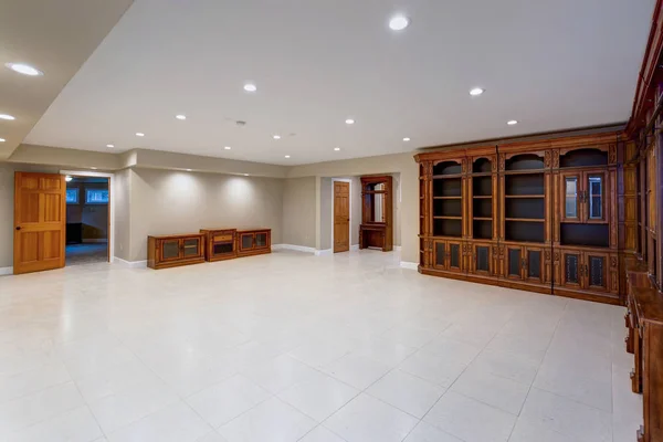 Spacious empty basement area with large custom built bookcase. — Stock Photo, Image