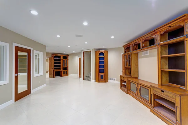 Spacious basement area with large custom built bookcase.