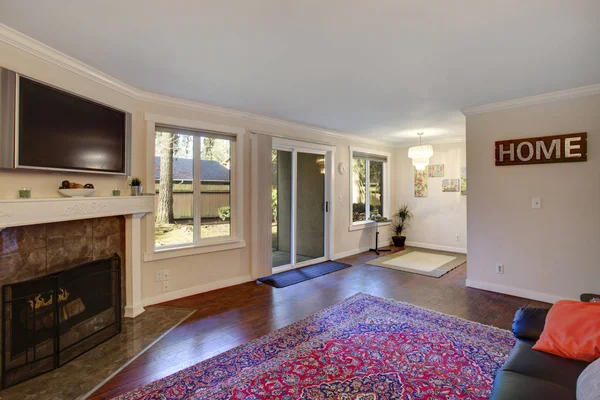 Interior of a living room with fireplace and attached dining area.