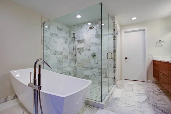 Elegante baño con bañera independiente y ducha a ras de suelo Fotos De Stock