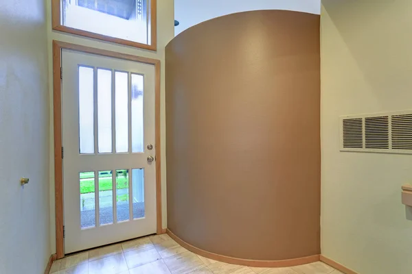 Empty apartment interior features entrance foyer with tan wall.