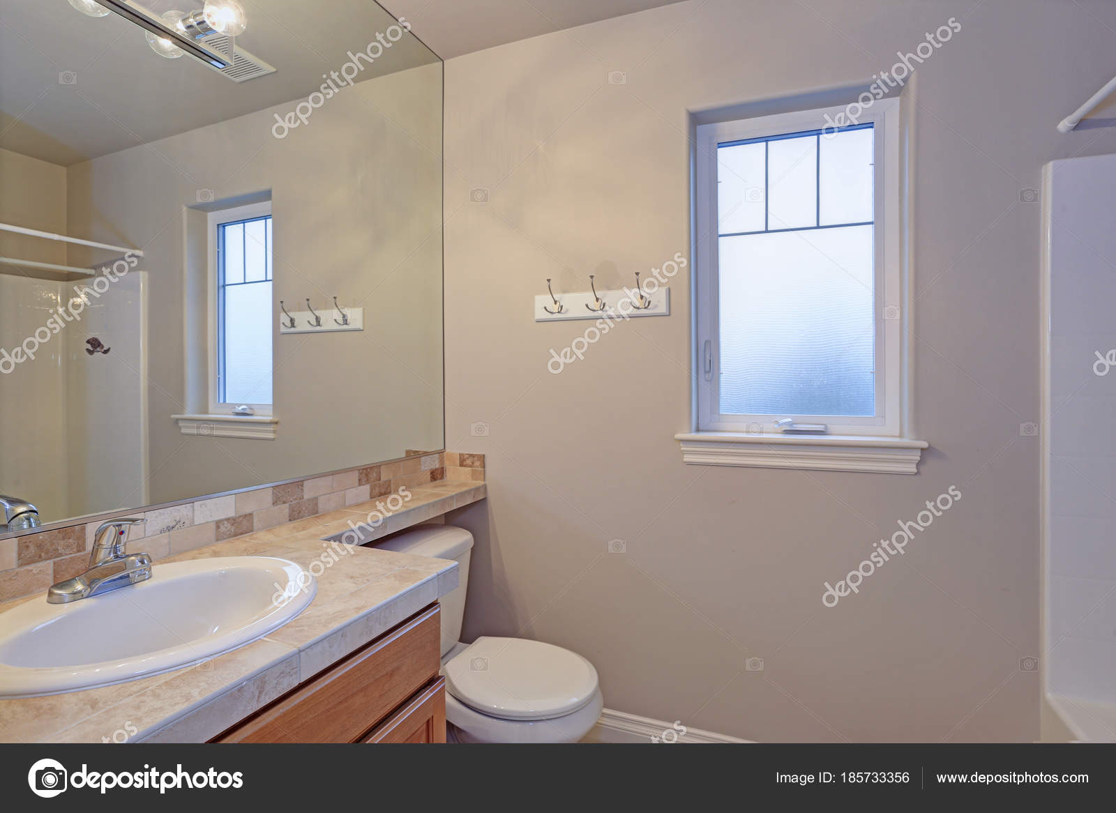 Light Bathroom Interior With Tiled Top Vanity Cabinet Stock