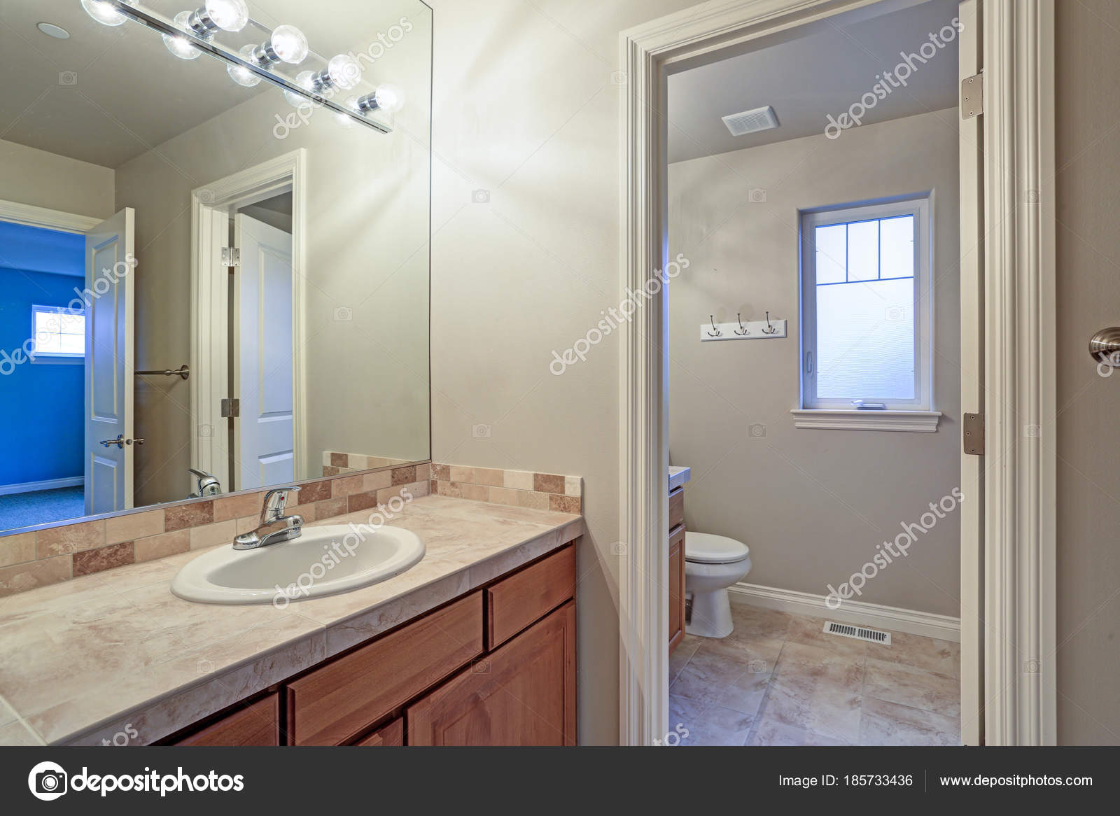 Light Bathroom Interior With Tiled Top Vanity Cabinet Stock