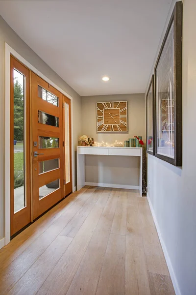 Elegante vestíbulo con una puerta frontal de cristal y una mesa de consola blanca — Foto de Stock