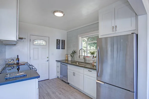 Cozy and small kitchen with white cabinets.