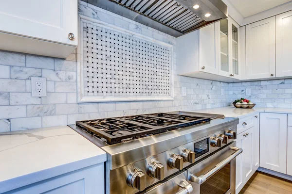 White Kitchen with stainless steel hood over gas cooktop. — Stock Photo, Image