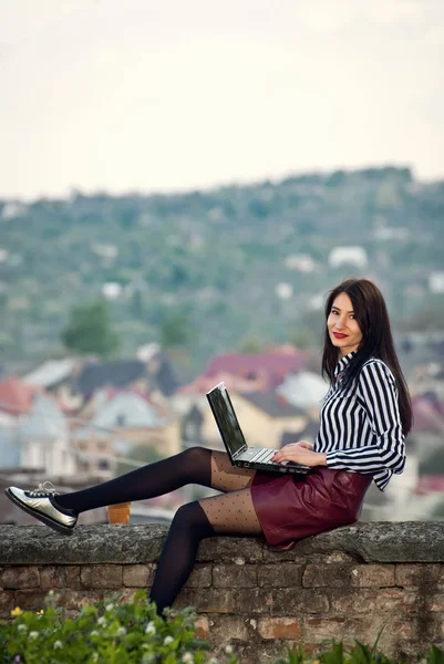 Ragazza si siede con un computer portatile nella natura — Foto Stock