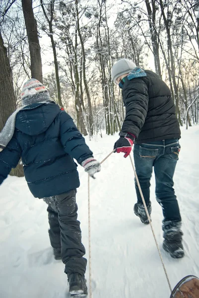 Two boys riding in sleigh in winter — Stock Photo, Image