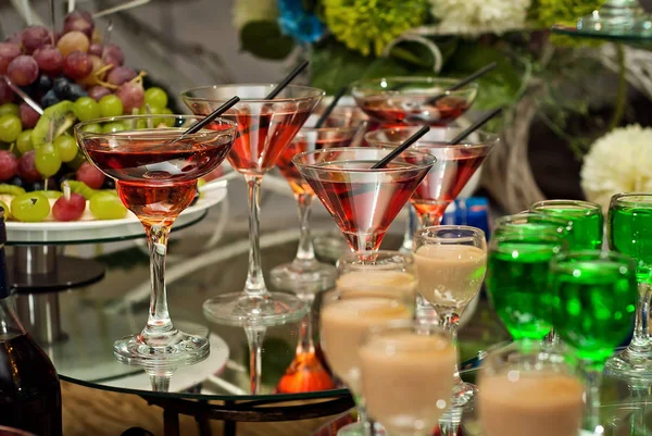 Glas glas med färgade drycker på bordet — Stockfoto