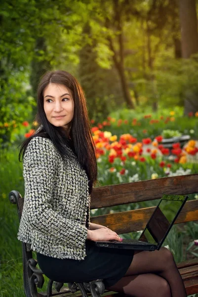 The girl sits in a park on a bench — Stock Photo, Image