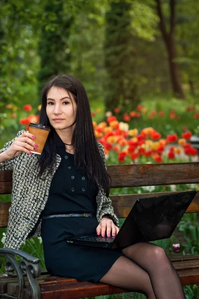 The girl sits in a park on a bench — Stock Photo, Image