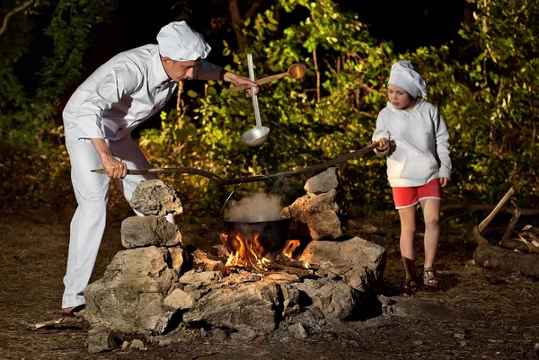 Le cuisinier prépare la nourriture sur le feu — Photo
