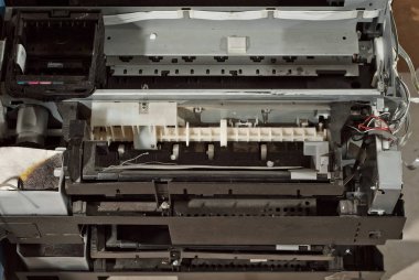 Yazıcı parçalarına ayrılır. Bozuk, kirli ve tozlu bir yazıcı. Ekipman onarımı için servis merkezi. Mürekkep ve baskı malzemelerinin temizlenmesi.