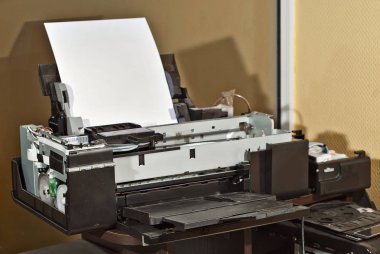 Yazıcı parçalarına ayrılır. Bozuk, kirli ve tozlu bir yazıcı. Ekipman onarımı için servis merkezi. Mürekkep ve baskı malzemelerinin temizlenmesi.