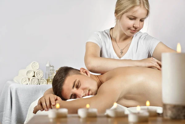 Girl Shirt Doing Massage Guy Candles Foreground Man Lying Table — Stock Photo, Image