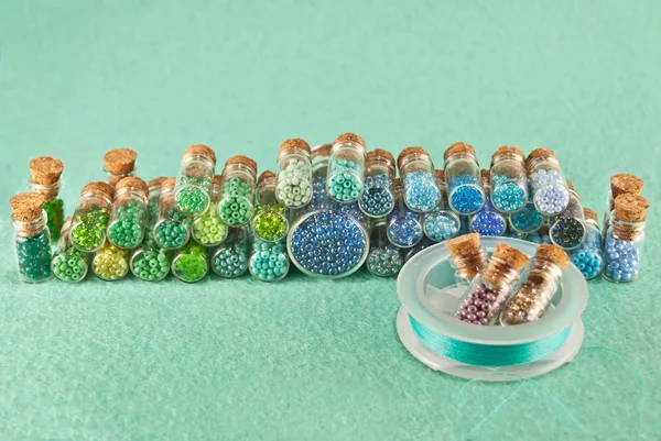 Blue Green Yellow Purple Beads Glass Jars Bright Cyan Background — ストック写真