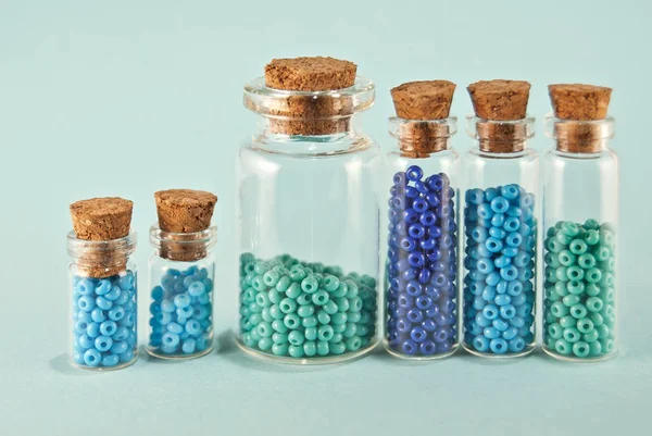 Cuentas Color Púrpura Cian Frascos Vidrio Sobre Fondo Azul Brillante — Foto de Stock