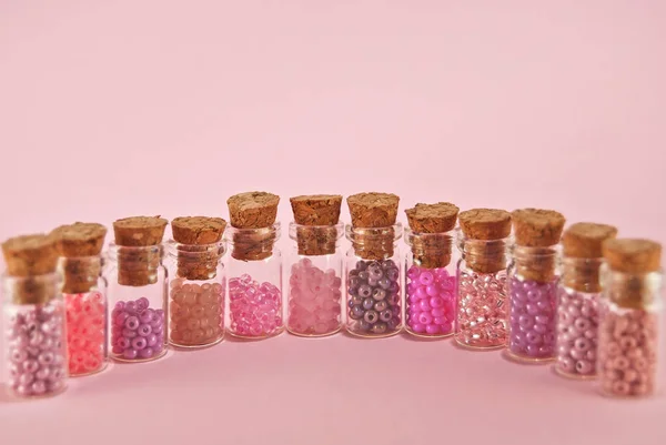 Beige Purple Orange Yellow Beads Glass Jars Bright Pink Background — Stock Photo, Image