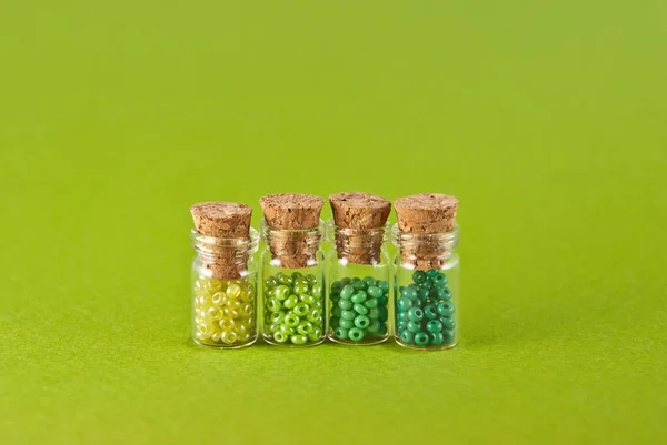 Green Yellow Beads Glass Jars Bright Green Background Beads Transparent — Stock Photo, Image