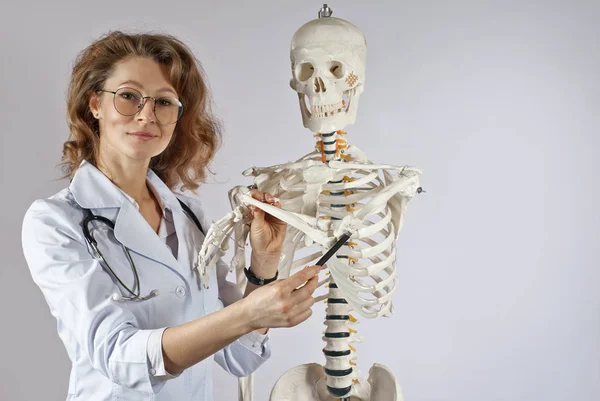 Tıbbi Giysili Kadın Skelet Yapısı Olan Bir Doktor Beyaz Arka — Stok fotoğraf
