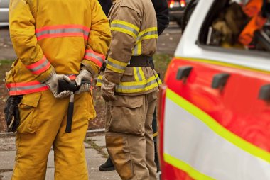 İtfaiyecileri eğitiyorum. Gösteri kurtarma çalışması. İtfaiyeci ekipmanlı itfaiye aracının yanında..