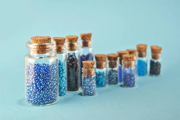 Cuentas Color Púrpura Cian Frascos Vidrio Sobre Fondo Azul Brillante — Foto de Stock
