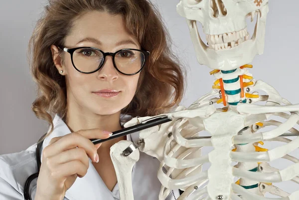 Tıbbi Giysili Kadın Skelet Yapısı Olan Bir Doktor Beyaz Arka — Stok fotoğraf