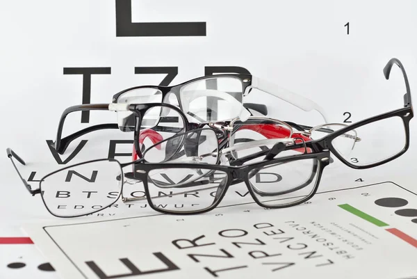 Glasögon Vit Bakgrund Bakgrund Med Bokstäver För Synprovning Många Glasögon — Stockfoto